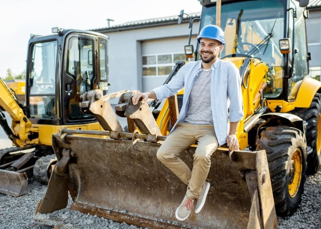 homebuilder standing by bulldozer