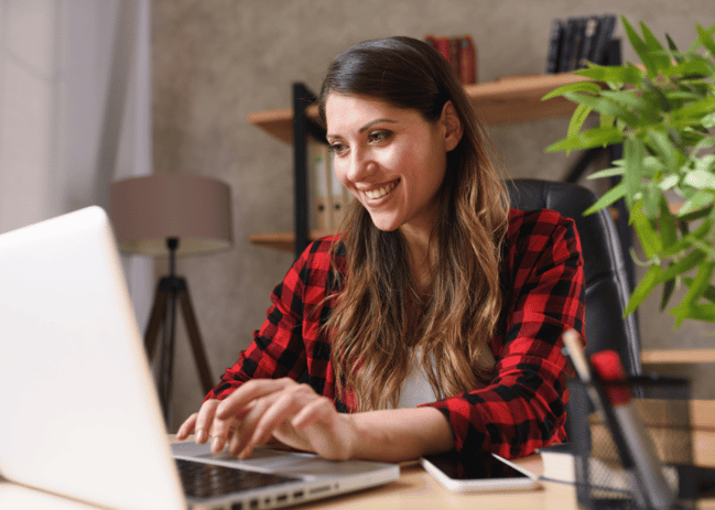 Woman smiling at her computer while typing