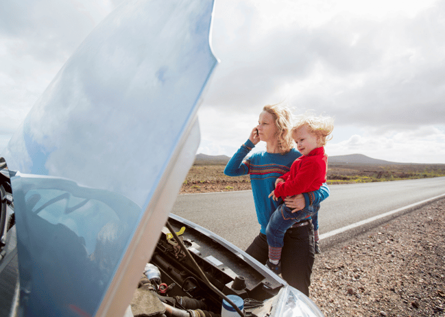 young mother with baby on hip broken down by side of the road (800 × 571 px)