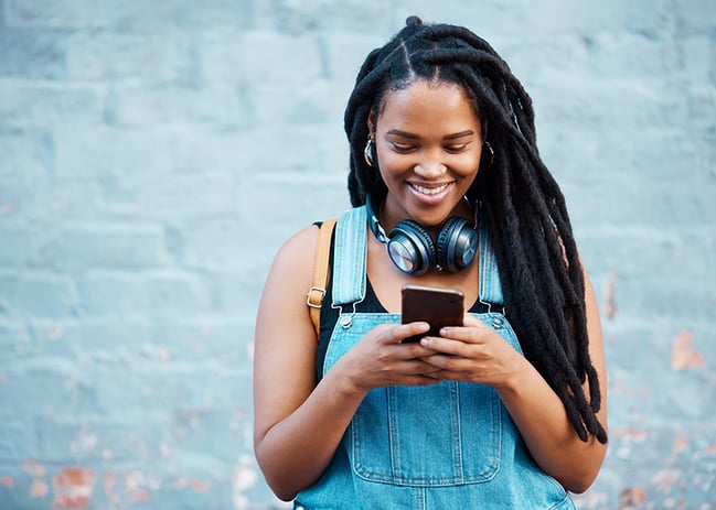 black woman smiling looking at smartphone_800x571