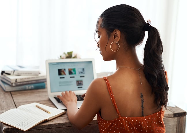 college student taking notes on  laptop computer