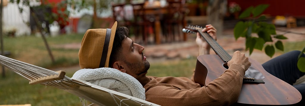 man playing guitar in hammock