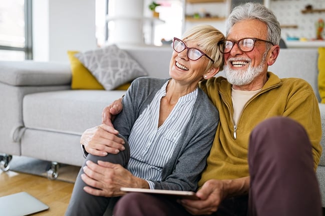 happy retired senior couple hugging and smiling