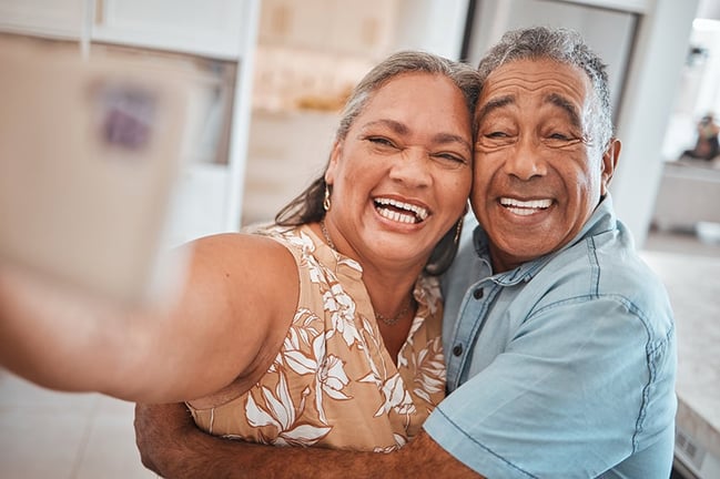 retired smiling couple taking a smartphone selfie