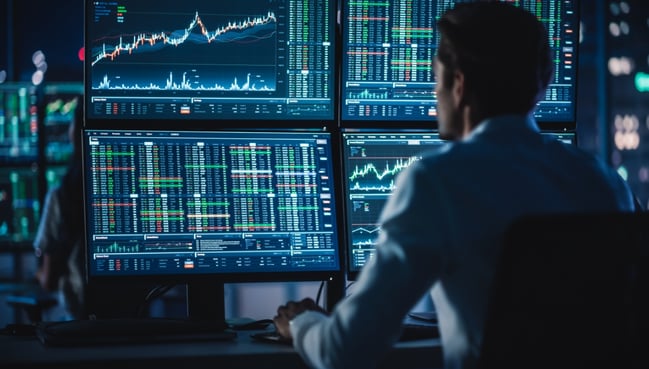 financial planner view stock performance on multiple computer monitors