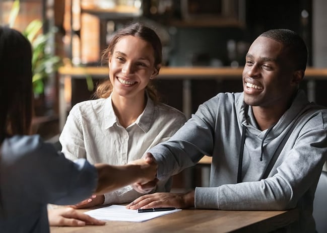 Happy couple meeting with mortgage lending specialist