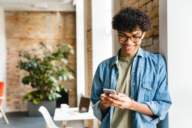 cheerful-young-businessman-using-phone-at-the-work-2026-01-07-02-02-17-utc
