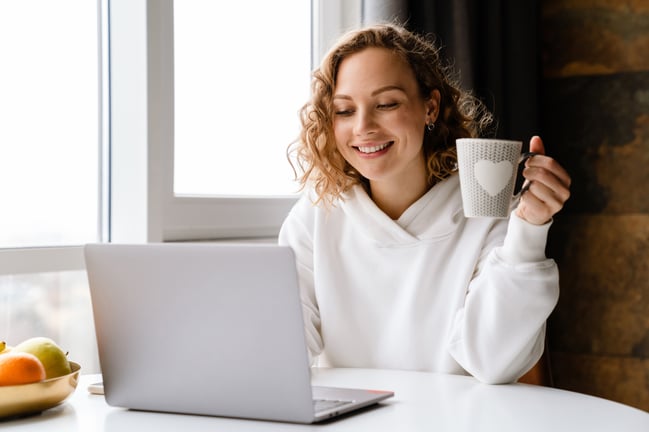 woman enjoys morning coffee while doing online banking