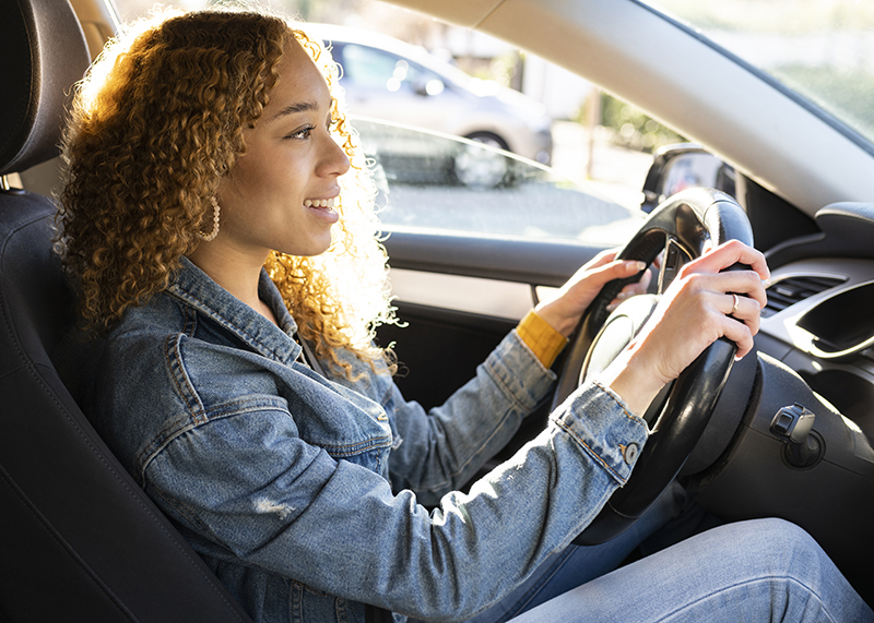 young hispanic woman driving auto