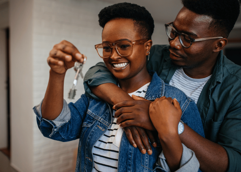 couple holding keys to their first house