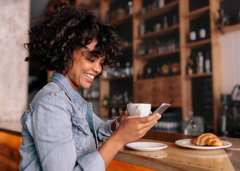 woman sitting in coffee shop looking at phone