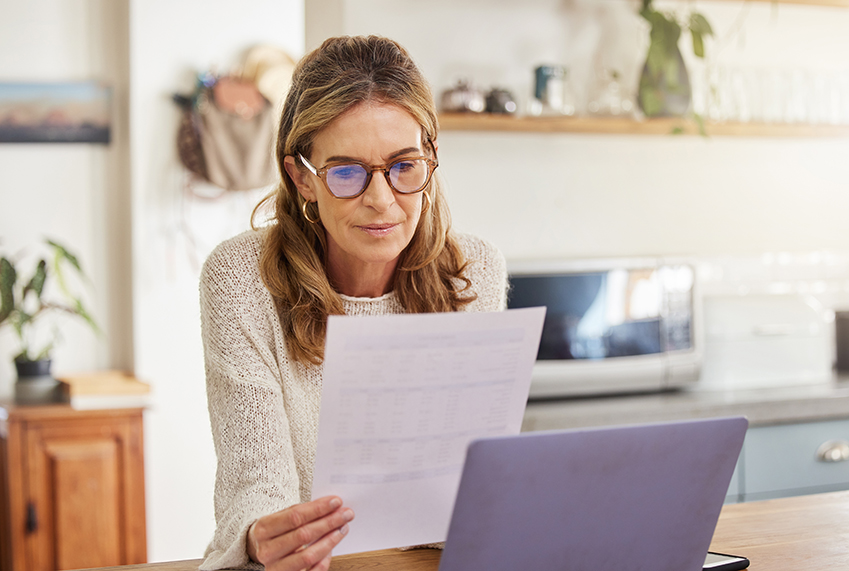 Retired woman reviewing investment portfolio documents