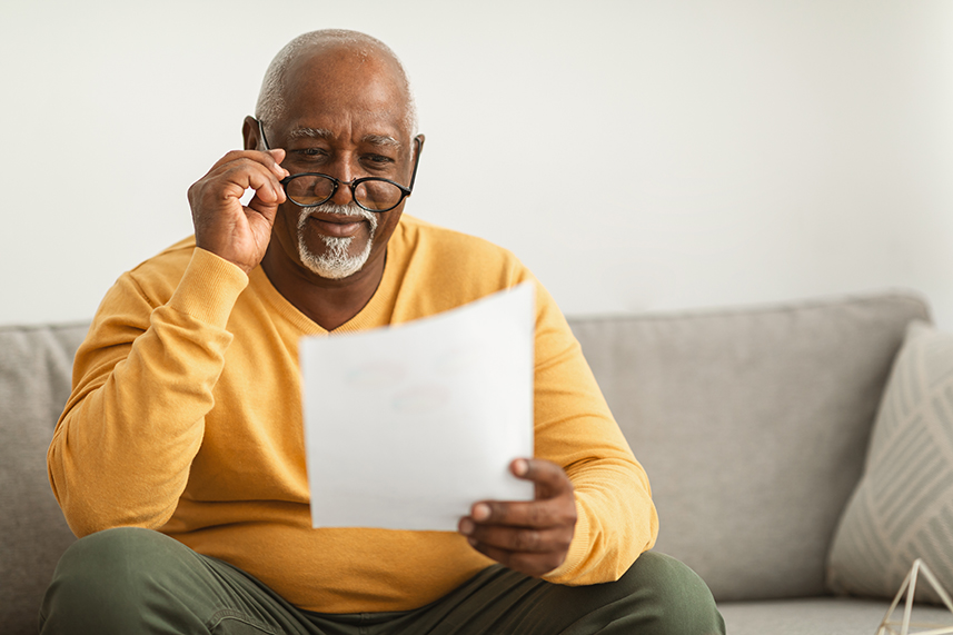 retired African american man reading over retirement financials