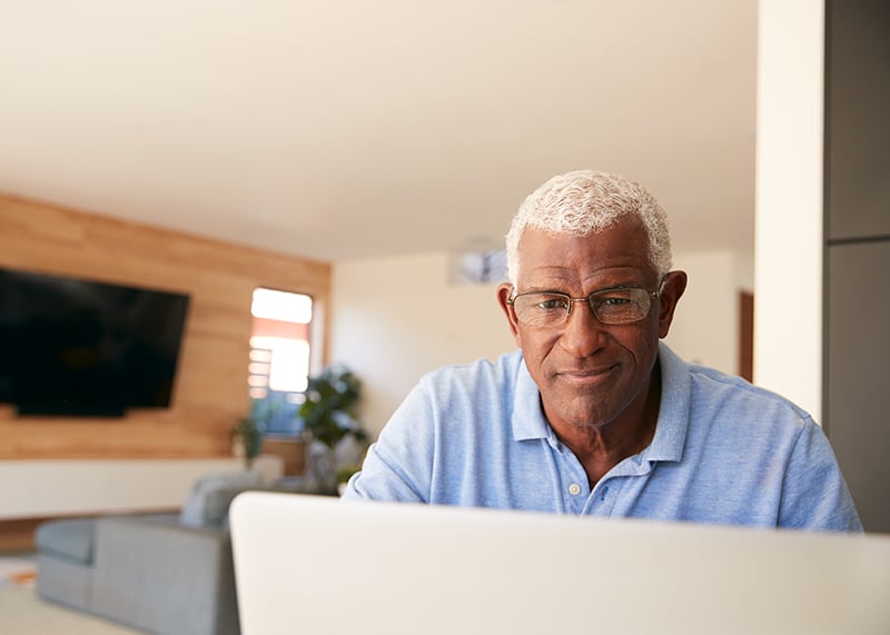 retired African American man using laptop to check inventments