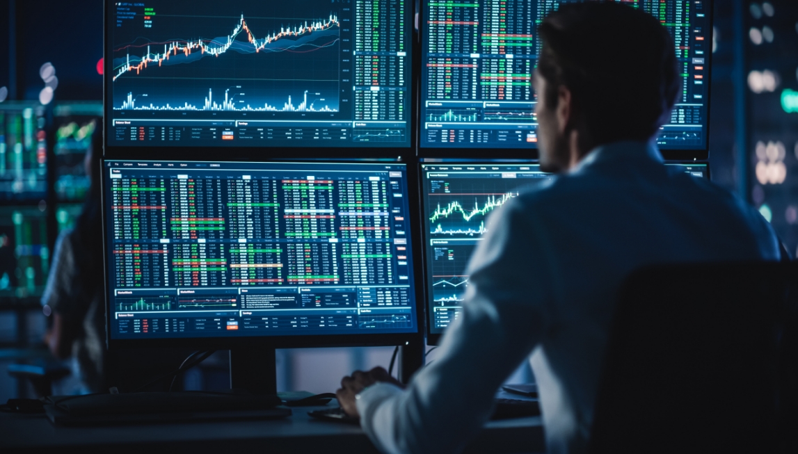financial planner view stock performance on multiple computer monitors